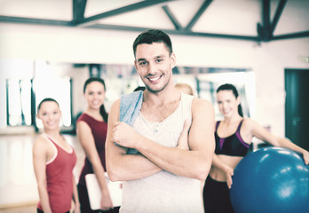 Fototapeta na wymiar smiling man standing in front of the group in gym