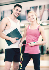 two smiling people with clipboard and measure tape