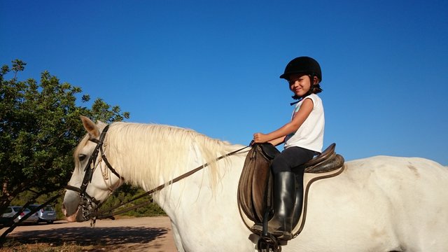 Ni&ntilde;a montada en caballo blanco