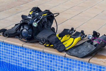 Scuba diving equipment on the edge of a pool