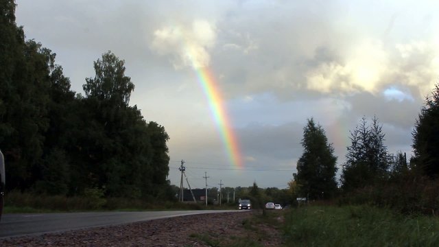 Rainbow in the sky above countryside road
