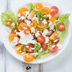 Salad with various types of tomatoes and feta cheese, close-up