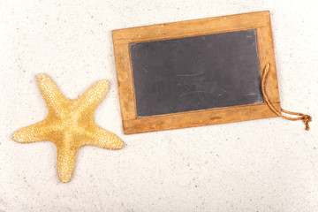Leere Schiefertafel mit Seestern im Sand