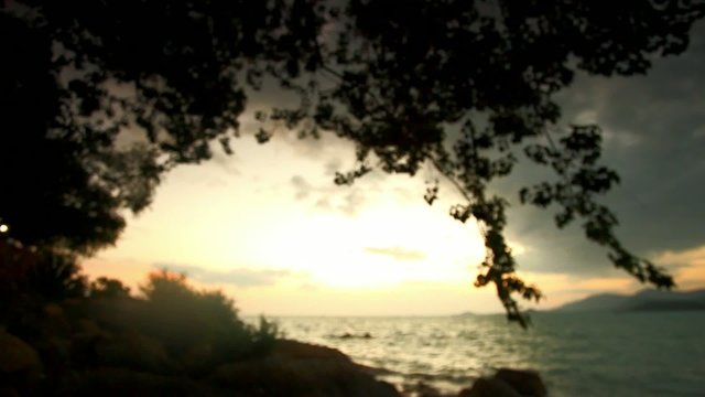 Sunset on a wild beach in Thailand. Blurred background
