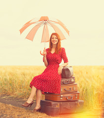 Redhead girl with suitcases at outdoor