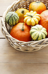 Basket of pumpkins on wooden table