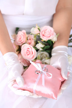 Bride in gloves holding wedding bouquet, close-up