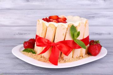 Tasty cake Charlotte with fresh strawberries on wooden table