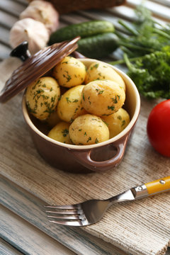 Young boiled potatoes in pan on wooden table