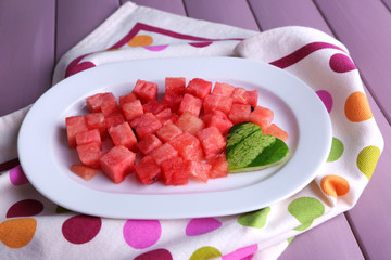 Slices of watermelon on polka dot napkin on wooden background