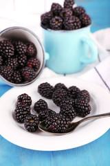 Sweet blackberries in mugs and