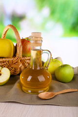 Apple cider vinegar in glass bottle and ripe fresh apples,