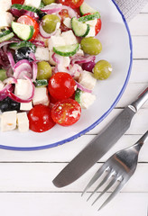 Greek salad served in plate on wooden background