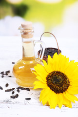 Sunflower with seeds and oil on table on bright background