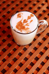 Cup of coffee with cute drawing in cafe