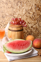 Composition of ripe watermelon, fruits and wooden barrel