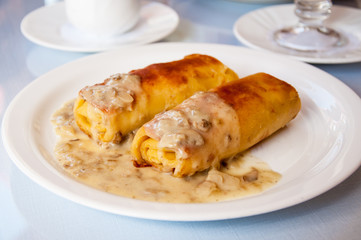 Pancakes with meat and mushroom sauce