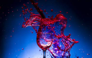 splash glass red wine blue background