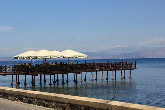 bar on a platform over sea with umbrellas