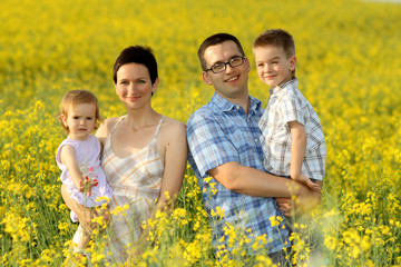 Fototapeta premium happy family in a field of yellow flowers