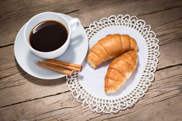 A cup of coffee and croissants