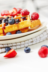 Golden waffles with berries and sauce