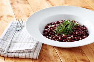 Kidney beens on white plate and vintage wooden table