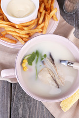 Tasty soup with oysters on wooden table
