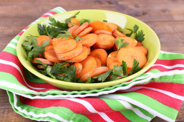 Slices of carrot, sorrel and parsley in green round bowl