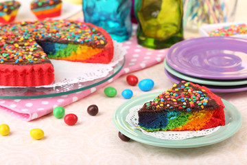 Delicious rainbow cake on table, on bright background