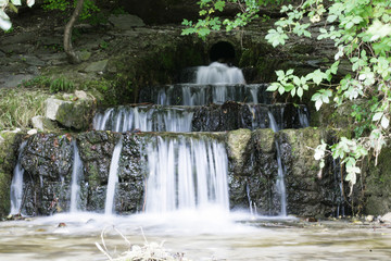 Fototapeta na wymiar Wasserfall in einem Bach - Frontansicht