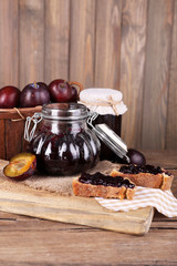 Tasty plum jam in jars and plums