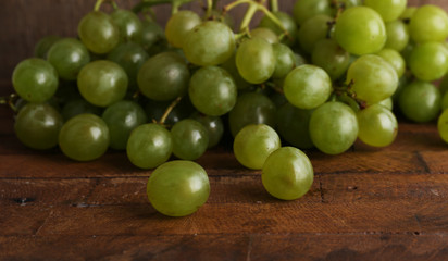 Green grape on wooden table on wooden background