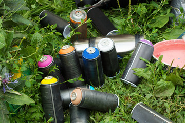 Colorful cans of paint on grass