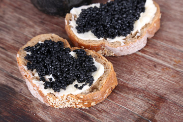 Slices of bread with butter and black caviar