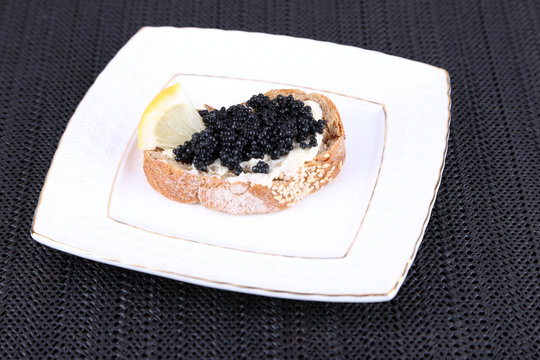 Slice of bread with butter and black caviar