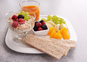 Slices of fruits with berries and muesli on table close up