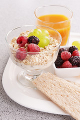 Slices of fruits with berries and muesli on table close up