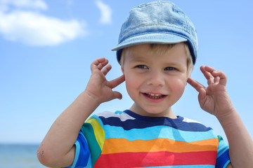 Small boy holds his hands over ears not to hear