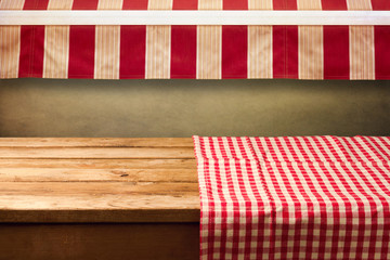 Obraz premium Empty wooden table covered with red checked tablecloth