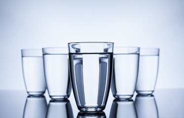 group of glasses filled with water on white background