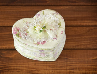 Gift box in a form of heart on wooden background