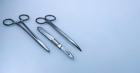 Three surgical instruments on blue.gray background