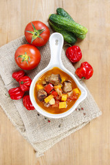 Bowl of goulash soup and fresh vegetables