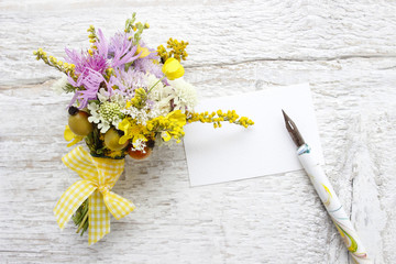 Bouquet of wild flowers on white wooden background