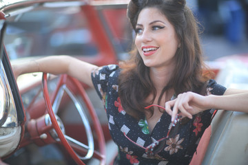 Fototapeta na wymiar Lovely Woman Posing and and Around a Vintage Car