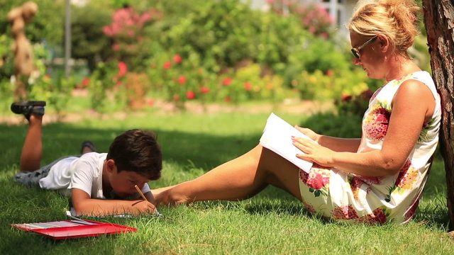 Child  painting,  mother reading a book in the park