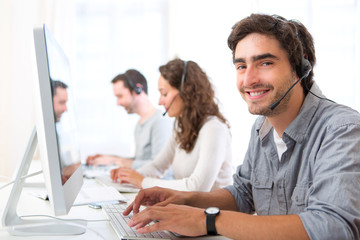 Young attractive man working in a call center