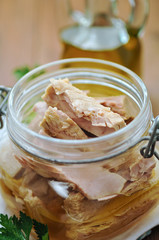 Tuna with parsley  in a glass jar on wooden table