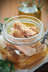 Tuna with parsley  in a glass jar on wooden table